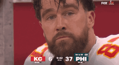 A Man With A Beard Wearing A Kc Jersey Is Watching A Football Game GIF