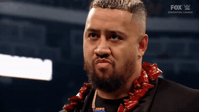 A Man With A Beard Wearing A Lei And A Fox Logo On The Bottom Of The Screen GIF