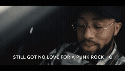 A Man With A Beard Wearing A Plaid Shirt And A Baseball Cap Says " Still Got No Love For A Punk Rock Ho " GIF
