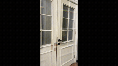 A Man With A Beard Wearing A Plaid Shirt Is Standing In Front Of A Window GIF