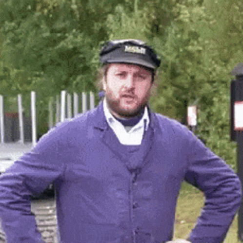 A Man With A Beard Wearing A Purple Jacket And A Black Hat With The Word Mobil On It GIF