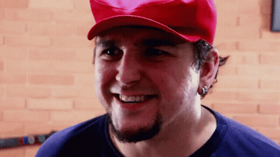 A Man With A Beard Wearing A Red Hat And Smiling GIF