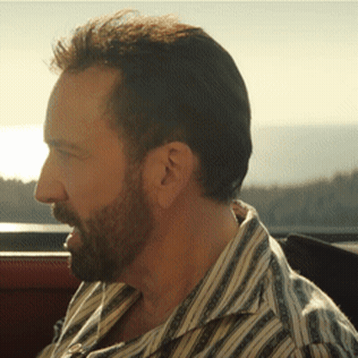 A Man With A Beard Wearing A Striped Shirt Looks To The Side GIF