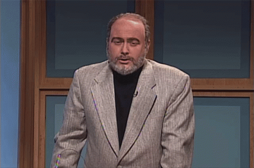 A Man With A Beard Wearing A Suit And A Black Turtleneck GIF