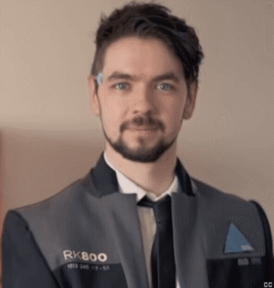 A Man With A Beard Wearing A Suit And Tie Is Looking At The Camera . GIF