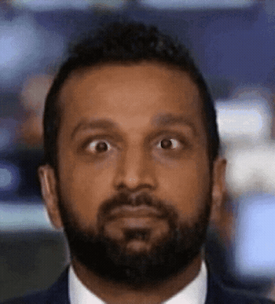A Man With A Beard Wearing A Suit And Tie Is Making A Funny Face GIF