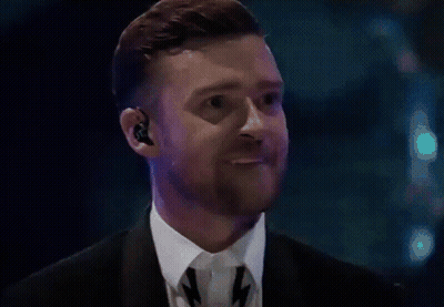 A Man With A Beard Wearing A Suit And Tie Is Making A Funny Face GIF
