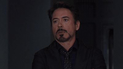 A Man With A Beard Wearing A Suit And Tie Looks At The Camera GIF