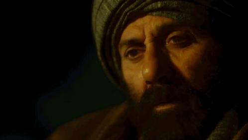 A Man With A Beard Wearing A Turban And A Scarf GIF