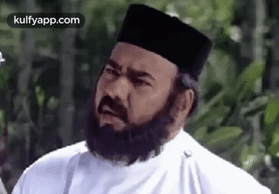 A Man With A Beard Wearing A White Shirt And A Black Hat . GIF