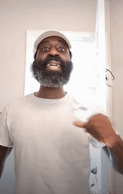 A Man With A Beard Wearing A White Shirt And Hat GIF