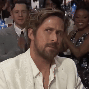 A Man With A Beard Wearing A White Suit And Tie GIF