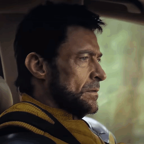 A Man With A Beard Wearing A Yellow Jacket And Black Gloves GIF
