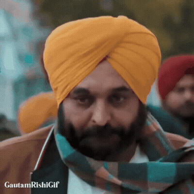 A Man With A Beard Wearing A Yellow Turban And A Green Scarf GIF