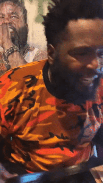 A Man With A Beard Wearing An Orange And Black Camo Shirt GIF