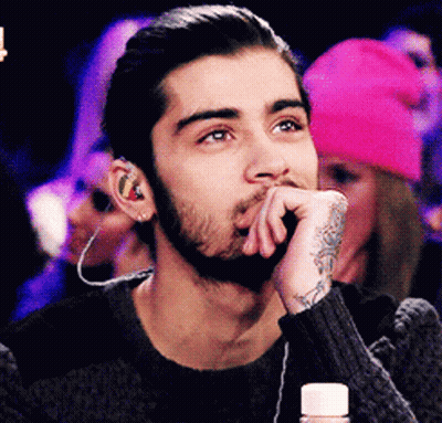 A Man With A Beard Wearing Ear Buds And A Tattoo On His Wrist GIF