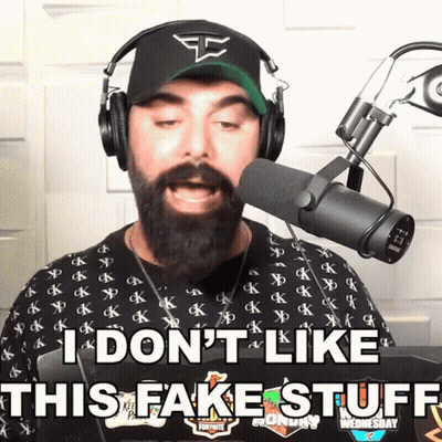 A Man With A Beard Wearing Headphones And A Hat Says I Don 'T Like This Fake Stuff GIF