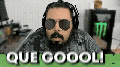 A Man With A Beard Wearing Headphones And Sunglasses Is Sitting In Front Of A Monster Energy Drink . GIF