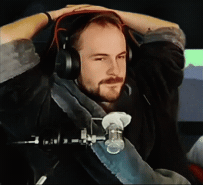 A Man With A Beard Wearing Headphones Is Sitting In Front Of A Microphone GIF