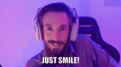 A Man With A Beard Wearing Headphones Is Smiling And Saying Just Smile . GIF