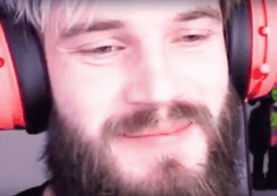 A Man With A Beard Wearing Headphones Is Smiling . GIF