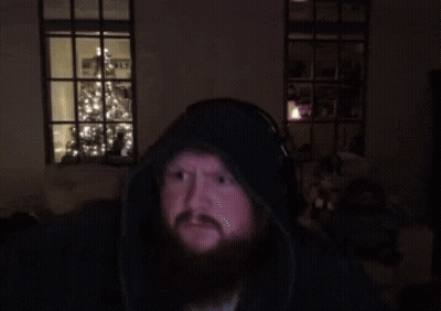 A Man With A Beard Wearing Headphones Looks At The Camera GIF