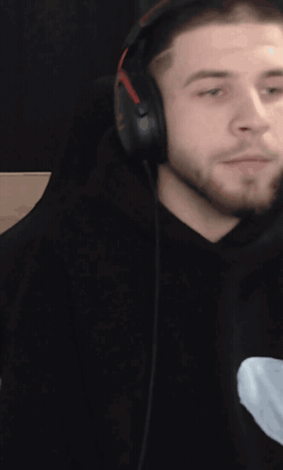 A Man With A Beard Wearing Headphones Looks To The Side GIF