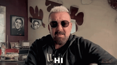 A Man With A Beard Wearing Sunglasses And A Hoodie That Says U Hi GIF