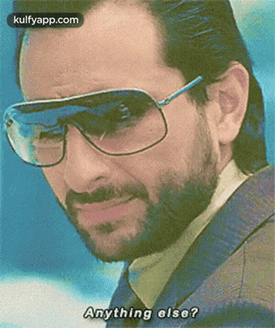 A Man With A Beard Wearing Sunglasses And A Jacket Is Asking Anything Else . GIF