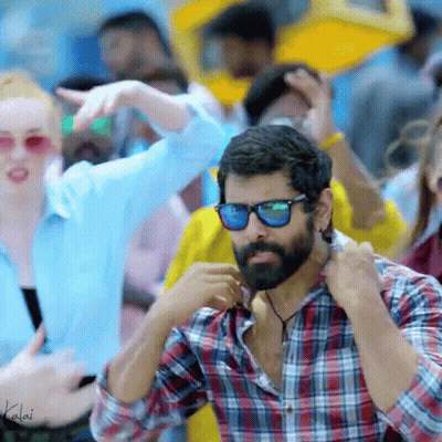 A Man With A Beard Wearing Sunglasses And A Plaid Shirt Is Standing In A Crowd GIF