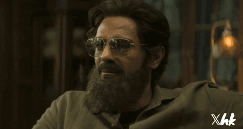 A Man With A Beard Wearing Sunglasses And A Shirt That Says Xhk On The Bottom GIF