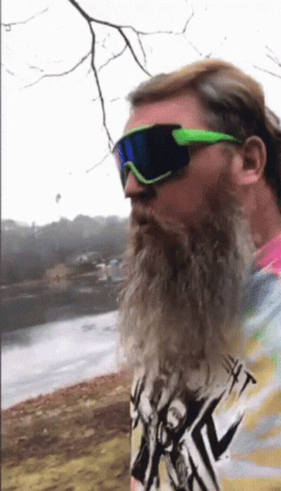 A Man With A Beard Wearing Sunglasses And A Tie Dye Shirt With A Picture Of A Man On It GIF