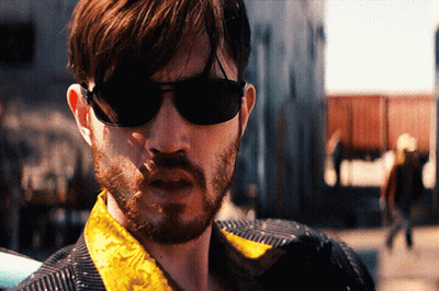 A Man With A Beard Wearing Sunglasses And A Yellow Jacket GIF