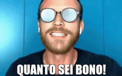 A Man With A Beard Wearing Sunglasses And Ear Buds Is Smiling And Saying Quanto Sei Bono ! GIF