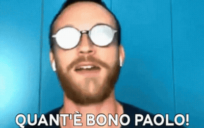 A Man With A Beard Wearing Sunglasses And Ear Buds Says Quant 'E Bono Paolo GIF