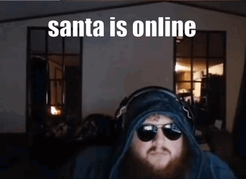 A Man With A Beard Wearing Sunglasses And Headphones With The Caption Santa Is Online GIF