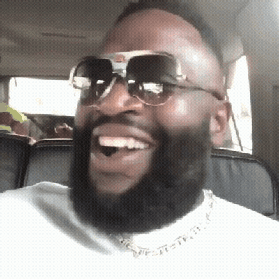 A Man With A Beard Wearing Sunglasses Is Smiling GIF