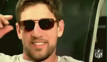 A Man With A Beard Wearing Sunglasses Is Smiling And Making A Funny Face . GIF