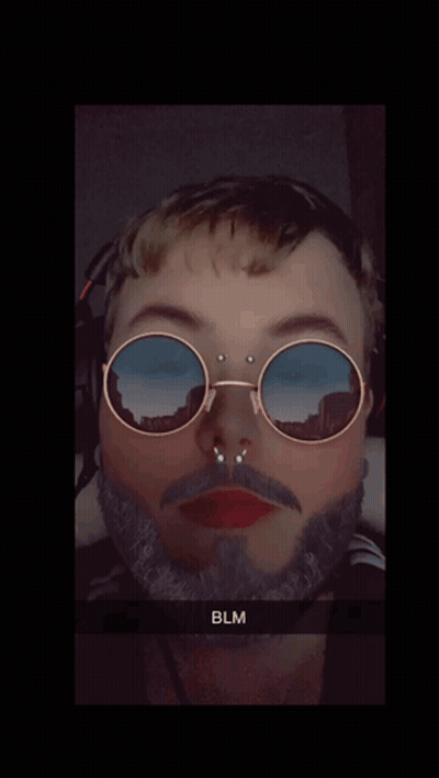 A Man With A Beard Wearing Sunglasses With A Reflection Of Mountains GIF
