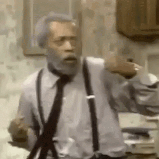A Man With A Beard Wearing Suspenders And A Tie Is Standing In A Kitchen . GIF