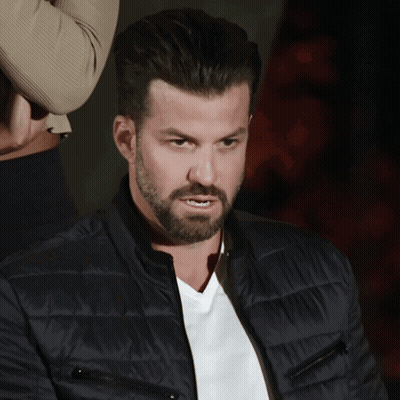 A Man With A Beard Wears A Black Jacket And A White Shirt GIF