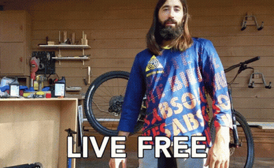 A Man With A Beard Wears A Blue Shirt That Says Live Free GIF