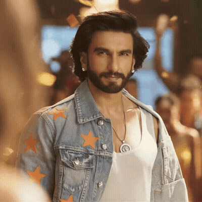 A Man With A Beard Wears A Denim Jacket With Orange Stars On It GIF
