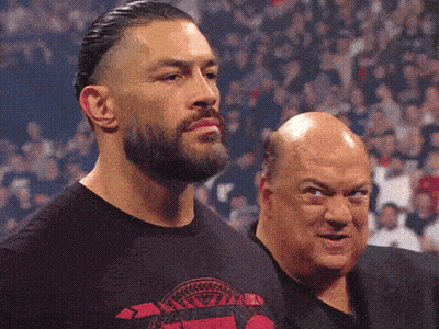 A Man With A Beard Wears A Shirt That Says ' Roman Reigns ' On It GIF