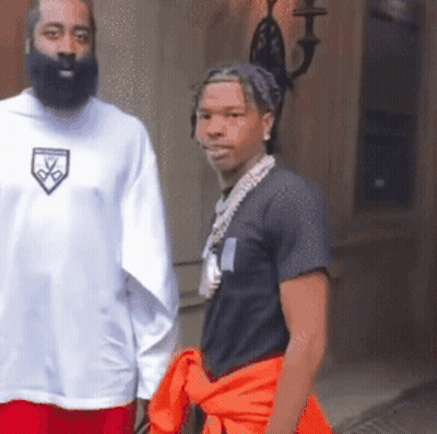 A Man With A Beard Wears A White Shirt With A Shield On The Front GIF