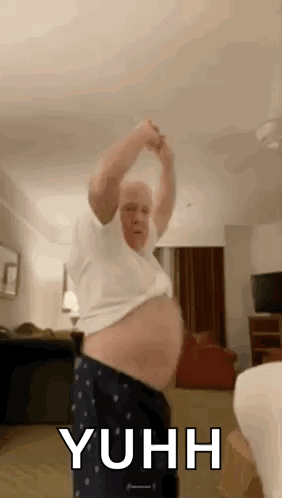 A Man With A Big Belly Is Dancing In A Room . GIF