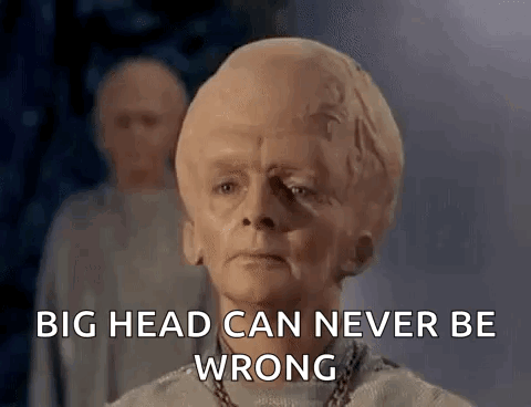 A Man With A Big Head Is Standing In Front Of A Group Of Men . GIF