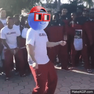 A Man With A Blue Ball On His Head Is Dancing In Front Of A Crowd Of People Wearing Oklahoma Shirts GIF