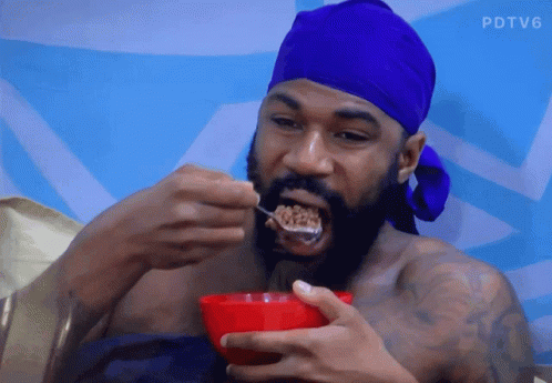 A Man With A Blue Headband Is Eating Cereal From A Bowl GIF