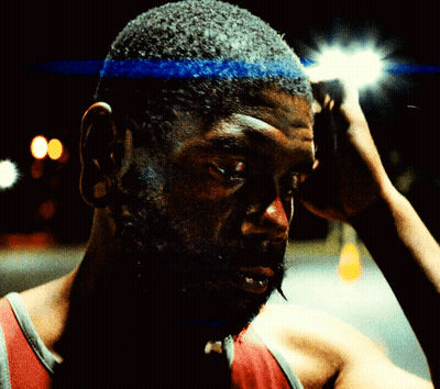 A Man With A Blue Headband On His Head Looks At The Camera GIF